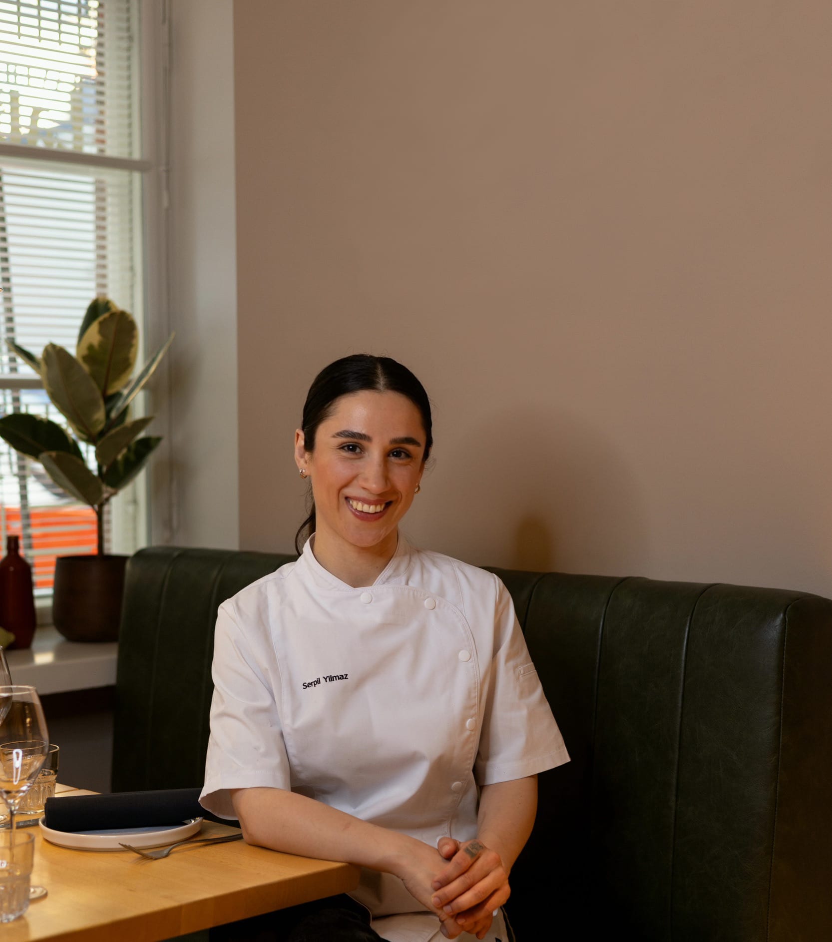 Chef Serpil Yilmaz-Rantanen seated in a restaurant dining room