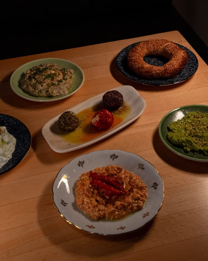 Small plates of dips, fresh simit bread, and cheese bites